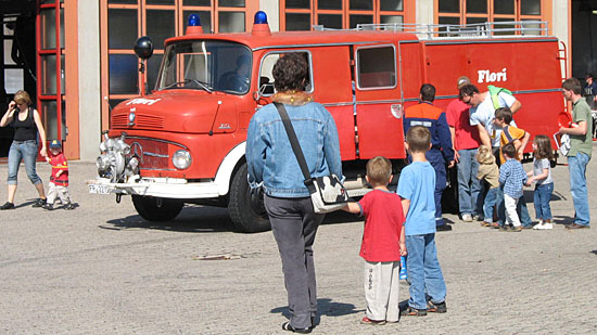 Kinder bestaunen ein Feuerwehrfahrzeug